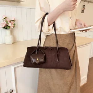 Detail view of stylish brown suede shoulder bag featuring a chic mini pouch and comfortable straps.