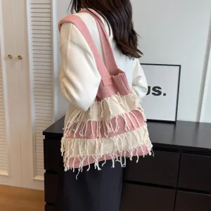 Knit tassel shoulder bag detail view, casual pink striped underarm bag for daily vacation.