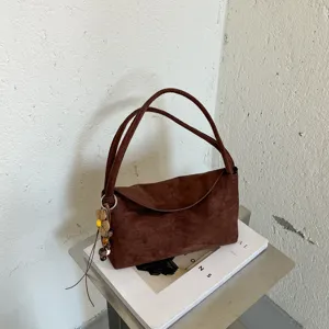 Vue détaillée du sac porté épaule en suédine marron, style hobo minimaliste avec charm.