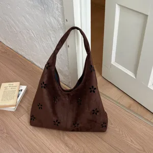 Dettaglio borsa a spalla hobo in camoscio marrone, accenti floreali, design minimalista quotidiano.