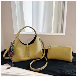 Detailed view of the yellow hobo dumpling bag with metal lock closure and small matching pouch.
