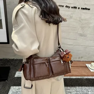 Brown leather shoulder bag with multi pockets and cute bear pendant for women daily commuting.