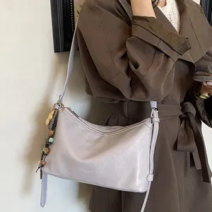 Stylish soft leather shoulder bag for women, trendy commuter crossbody bag with chic charms.