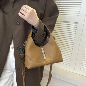 Brown leather hobo shoulder bag detail view, showcasing metal lock and premium texture.