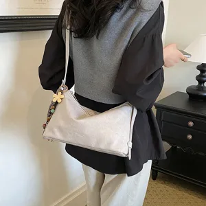 Stylish women's shoulder bag large capacity casual commuter handbag with flower pendant decor.