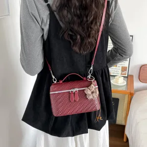 Vista dettagliata dell'elegante borsa a mano intrecciata con manico e tracolla.