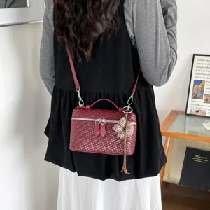 Dettaglio della borsa a tracolla intrecciata rosso scuro elegante per donna chic.