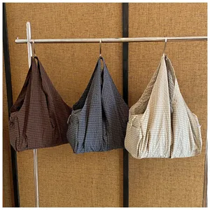 Vista detallada del bolso tote casual grande de tela con sutil textura de cuadrícula.