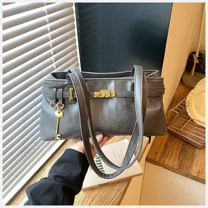 Detailansicht der dunkelgrauen Vintage Achseltasche mit schickem Goldschloss und Schlüssel.