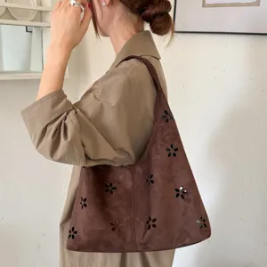 Borsa a tracolla hobo in camoscio marrone con eleganti dettagli floreali traforati.