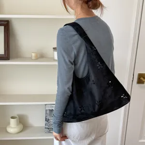 Borsa a spalla nera in camoscio da donna, elegante borsa a secchiello con fiori intagliati.