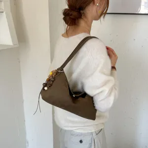 Vue détaillée du sac porté épaule marron en suédine pour femme avec perles et style.