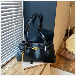 Klassische schwarze PU-Leder Achsel-Umhängetasche mit goldenen Beschlägen und schickem Schlüsselanhänger.
