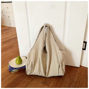 Vista detallada del bolso tote de lona vichy beige, que muestra tela suave y estilo casual.