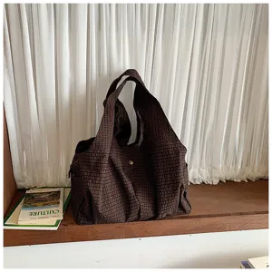 Vista detallada del elegante bolso tote de cuadros marrones en el alféizar, bolso casual.