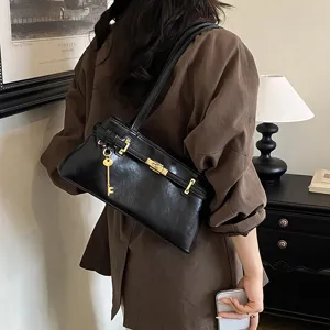 Detailaufnahme der schwarzen Vintage Schultertasche mit goldenem Schloss und Schlüssel.