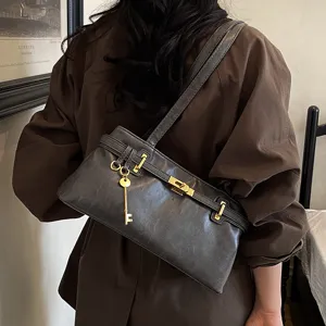 Detailansicht der eleganten dunkelgrauen Schultertasche mit schickem goldenen Schlüssel.
