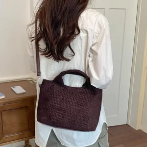 Clásico bolso de hombro tejido marrón oscuro mostrado en escena casual diaria, detalle.