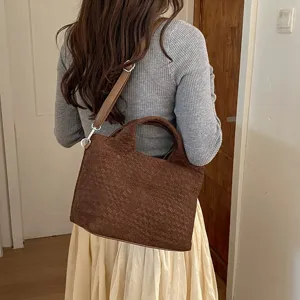 Detalle de bolso tote tejido marrón casual que muestra la correa, bolso elegante diario.
