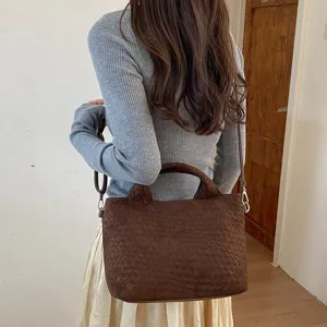 Vista detallada del elegante bolso de hombro tejido con textura premium para el estilo diario.