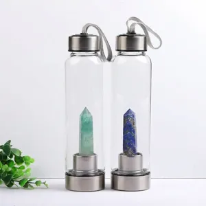 Two clear glass water bottles with natural fluorite and lapis lazuli crystal pillars.