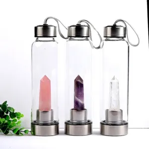 Three glass water bottles with natural crystal points inside for energy infusion