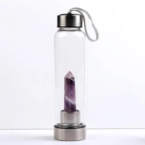 Detail of a natural purple amethyst crystal pillar inside a clear glass water bottle