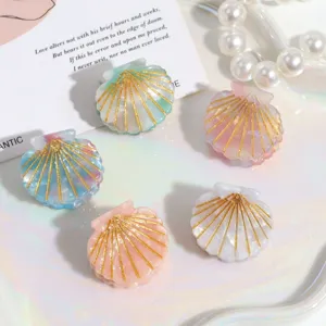 Set mit Mini-Muschel-Haarklammern in Pastellfarben und goldenen Glitzerdetails