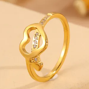 Gold plated titanium steel ring featuring asymmetric heart design with sparkling clear stones.