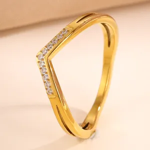 Gold V-shaped chevron ring detail with sparkling pave cubic zirconia stones in fine finish.