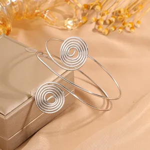 Bracciale da braccio a spirale argentato minimalista nel dettaglio, bijoux aperto per le vacanze.