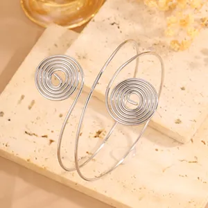 Primo piano dettagliato del bracciale da braccio in metallo argentato minimalista con design unico.