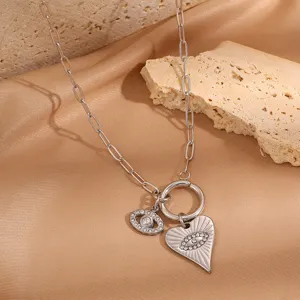 Evil eye heart pendant necklace detail, silver titanium steel paperclip chain close-up view.