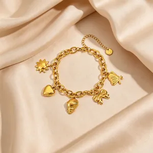 Gold plated stainless steel multi-charm bracelet featuring sun, heart, shell, and bow pendants.