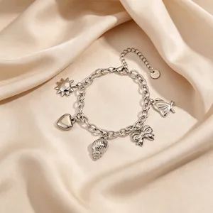 Silver multi-charm stainless steel bracelet with bow, heart, sun, and shell pendants.
