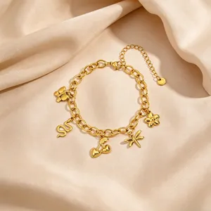 Gold multi-charm bracelet detail featuring butterfly snake heart and flower pendants on satin.