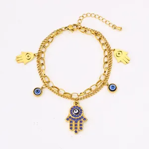 Gold stainless steel double layer hamsa hand bracelet with evil eye charms and blue crystals.