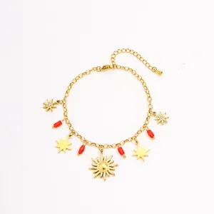 Detail view of gold-plated stainless steel charm bracelet featuring sun and star pendants.