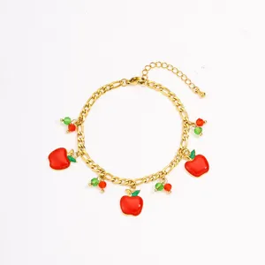 Detail view of gold stainless steel bracelet featuring charming red apple fruit pendants and beads.