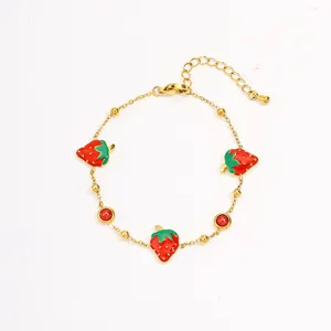 Close-up detail of gold-plated stainless steel bracelet featuring cute red enamel strawberry charms.