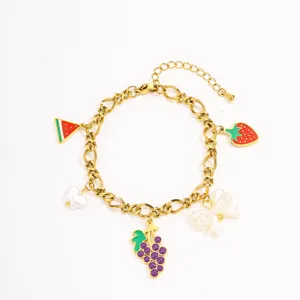 Detail view of gold plated stainless steel fruit charm bracelet with cute strawberry and grape.