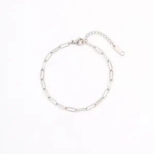 Detail view of minimalist stainless steel paperclip chain bracelet with extension and tag.