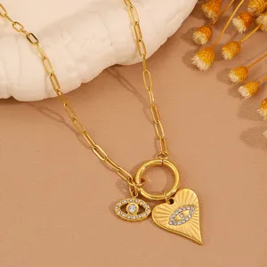 Gold paperclip chain necklace with evil eye and heart charms, stylish fashion jewelry for women.