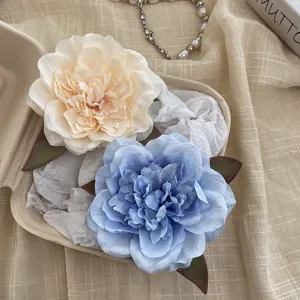 Close-up detail of large peony hair clip, showing delicate petal texture for beach holiday.