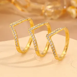 Close-up detail of three elegant geometric V-shaped gold rings featuring sparkling paved zirconia stones.