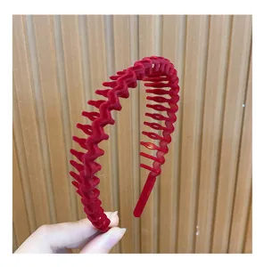 Close-up of red velvet zigzag hair hoop showing soft texture and anti-slip teeth detail.