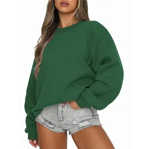 Vue détaillée du sweat-shirt vert à col rond, présentant une coupe ample et un tissu polaire doux.