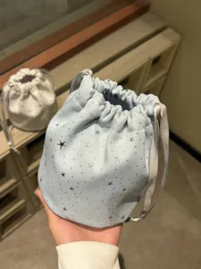 Detailed view of light blue star print drawstring pouch, cute cosmetic and mini organizer bag.