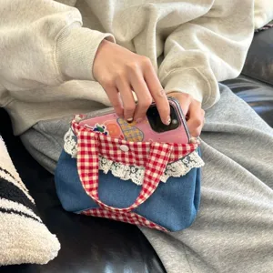 Detailed view of the Korean sweet denim handbag with red gingham trim and delicate lace edge.