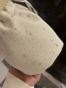 White drawstring pouch featuring silver star and dot studs for daily storage and makeup.
